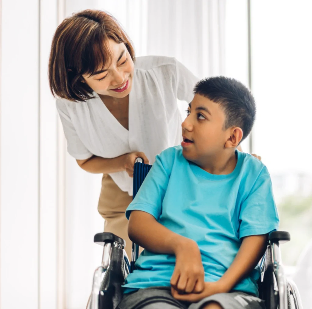 nurse helping young disabled boy on wheelchair
